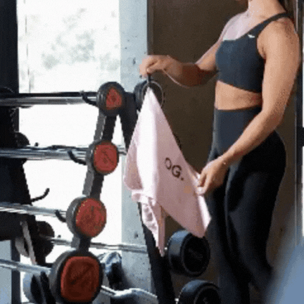 nlyGear GIF demonstrating N50 magnet attachment — A woman secures the towel to a gym machine, showcasing its strong magnetic feature